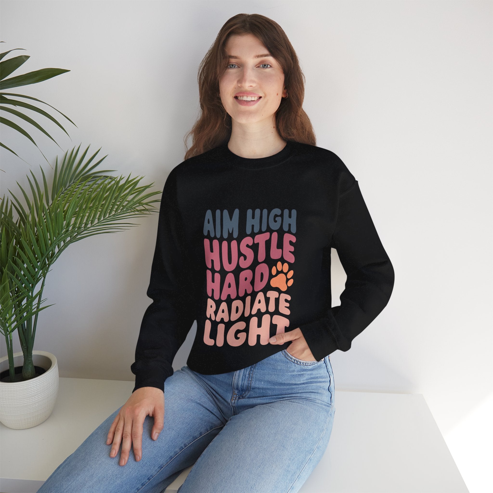 Unisex crewneck sweatshirt, black, worn by model; multicolor “AIM HIGH” graphic on front