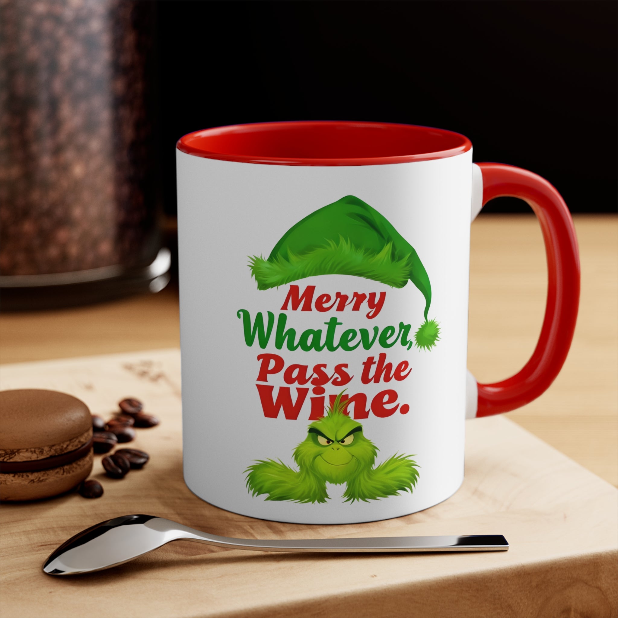 White mug with red rim and handle; green character graphic, 'Merry Whatever Pass the Wine.'