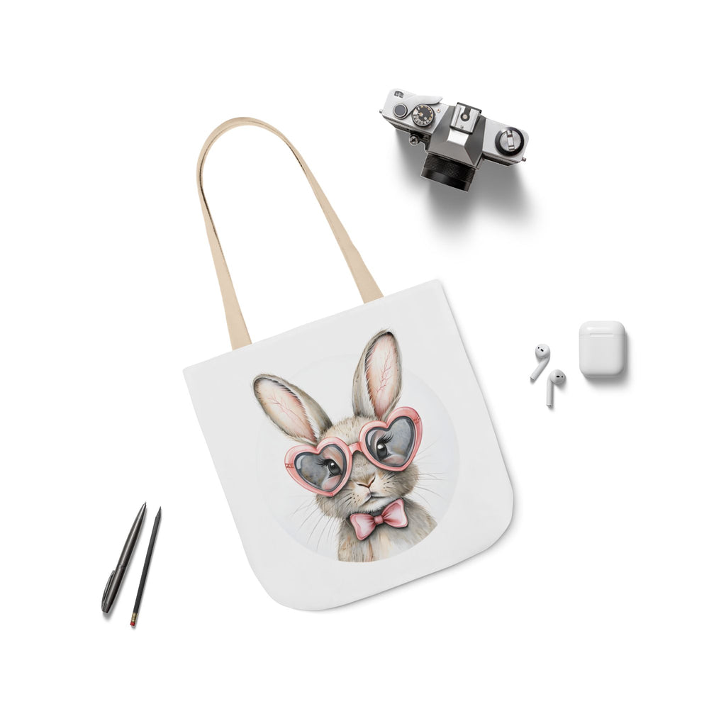 Canvas tote bag with bunny face print, beige strap, and small accessory items shown