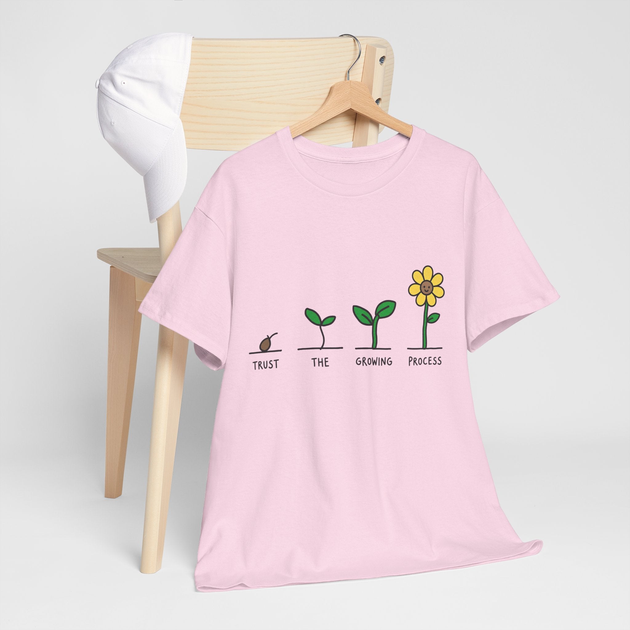 Pink crewneck T-shirt with seedling-to-flower graphic and small slogan text