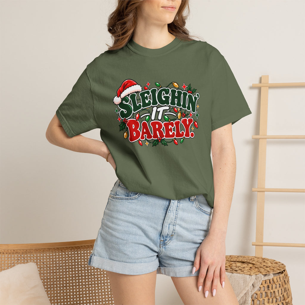 Olive green unisex crewneck Christmas graphic t-shirt worn by model, “Sleighin’ it Barely”