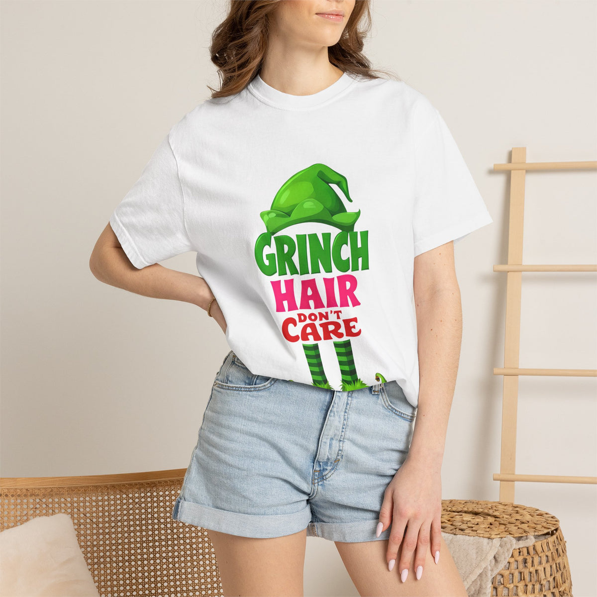White graphic t-shirt worn by model with green “Hair Don’t Care” character print