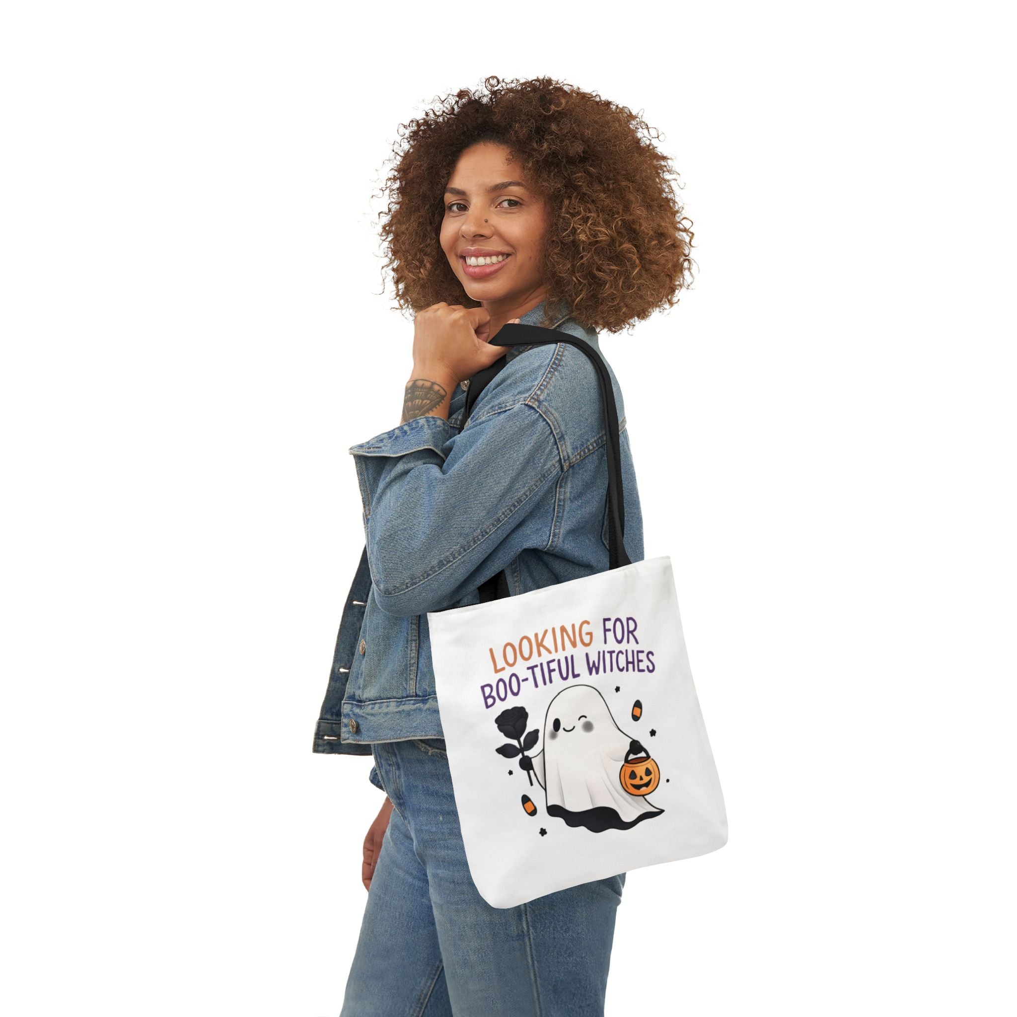 White tote bag with black handles; ghost and pumpkin Halloween graphic, carried at side