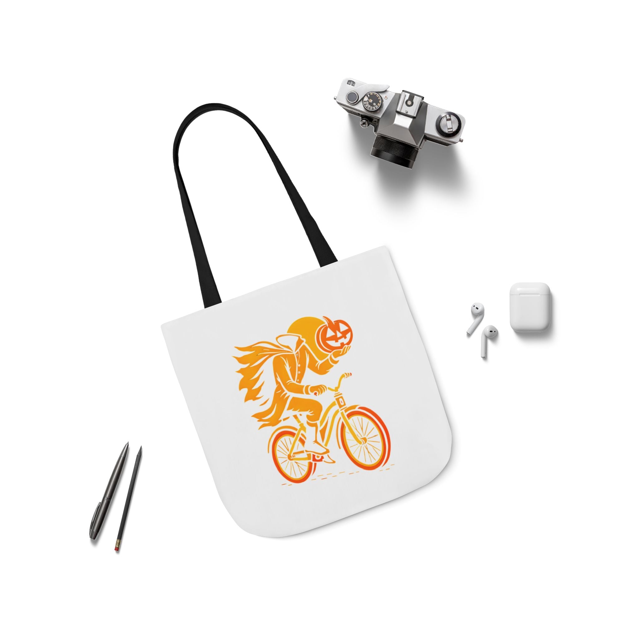 White canvas tote bag with black handles, orange ghost rider on bike graphic