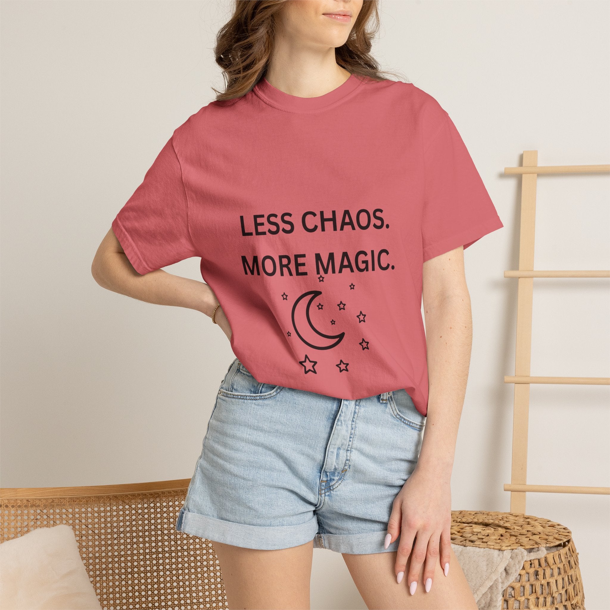 Pink crewneck T-shirt worn with “Less Chaos, More Magic” and crescent moon/star graphic