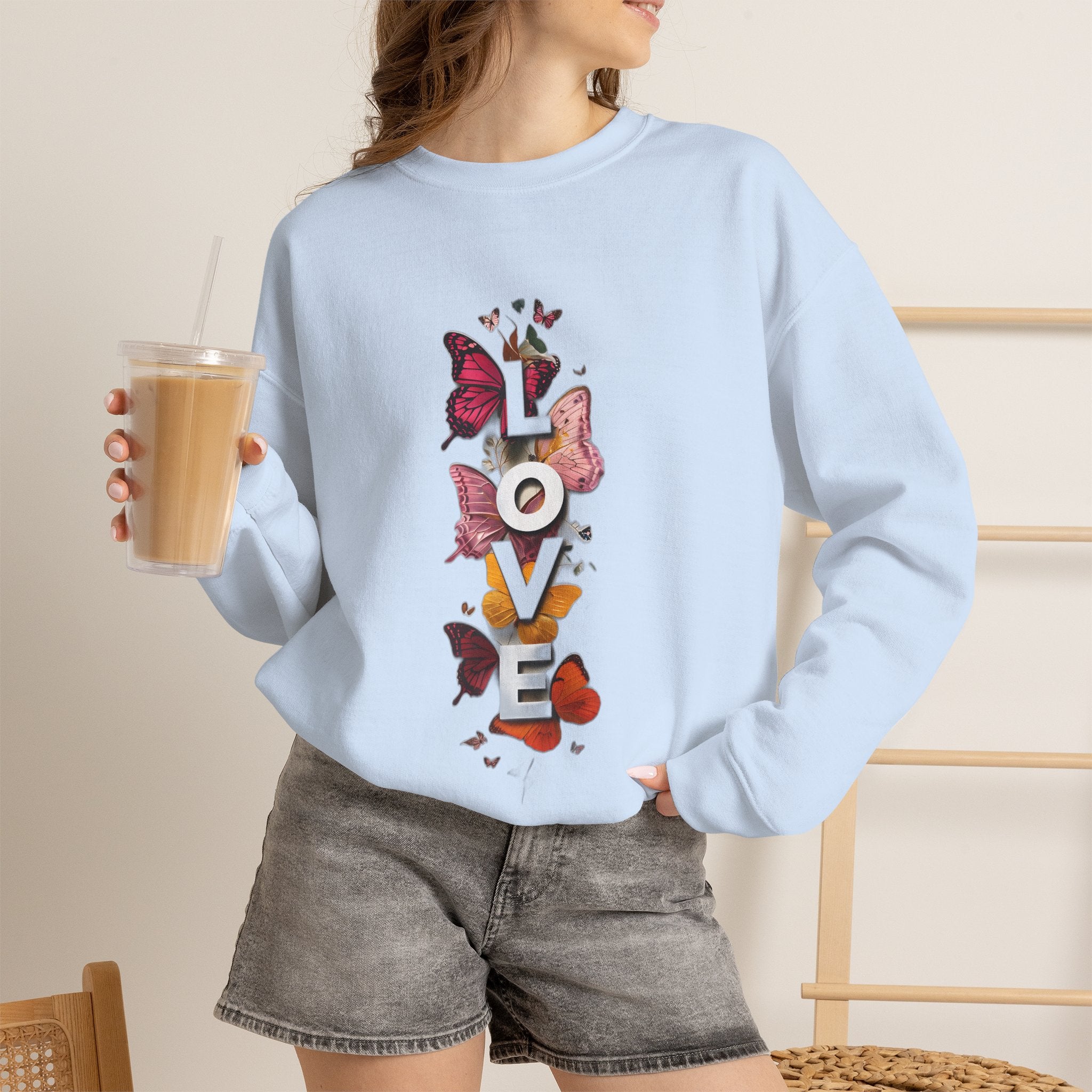 Light blue crewneck sweatshirt with colorful butterfly “LOVE” graphic on front