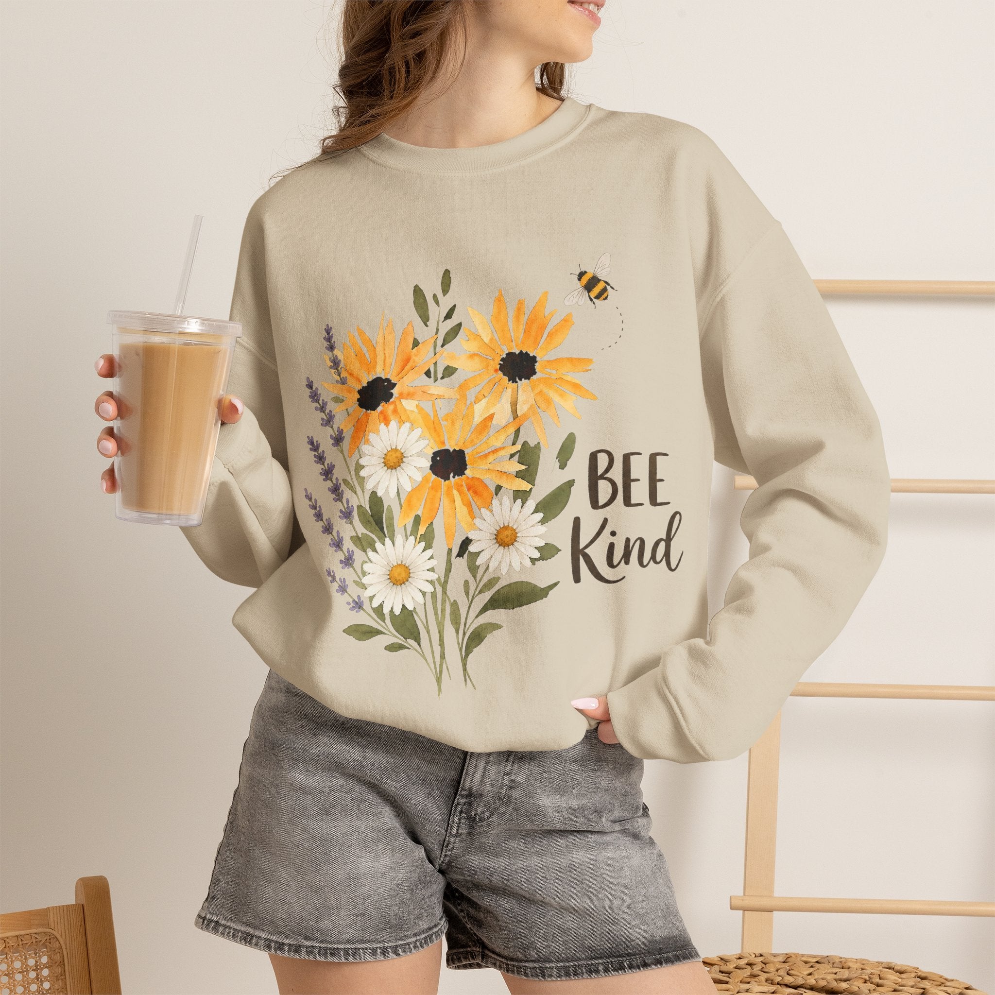 Beige crewneck sweatshirt with sunflower bouquet graphic and 'Bee Kind' text