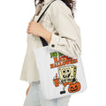 White canvas tote bag with black handles and cartoon Halloween graphic print
