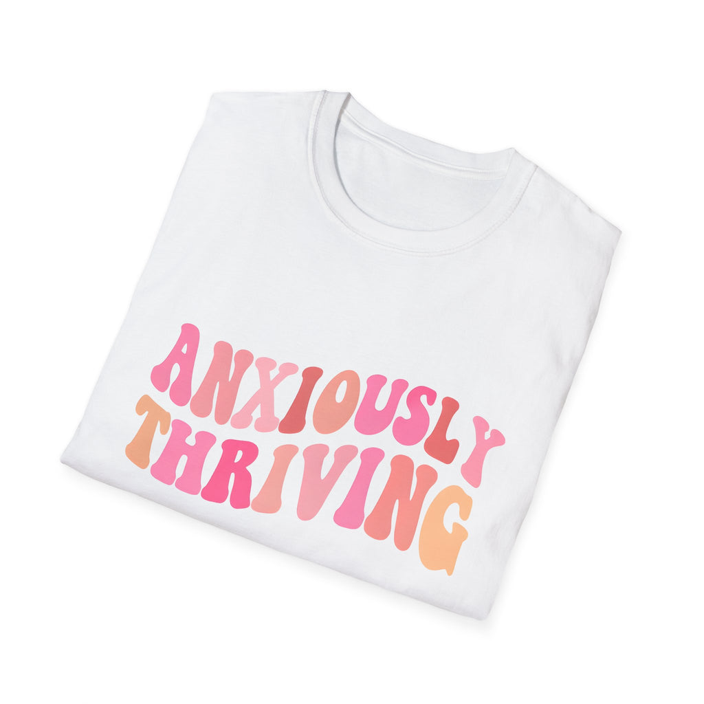 Unisex white T-shirt laid flat with 'ANXIOUSLY THRIVING' graphic on the chest