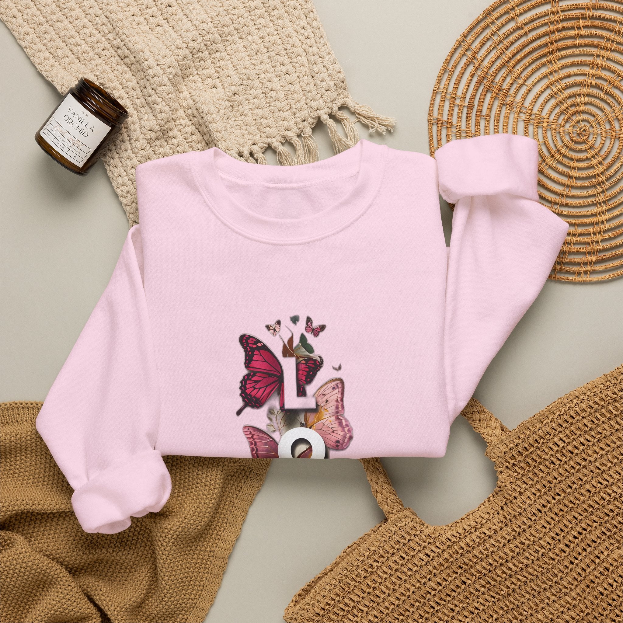 Light pink sweatshirt with long sleeves and Love word butterfly graphic on front