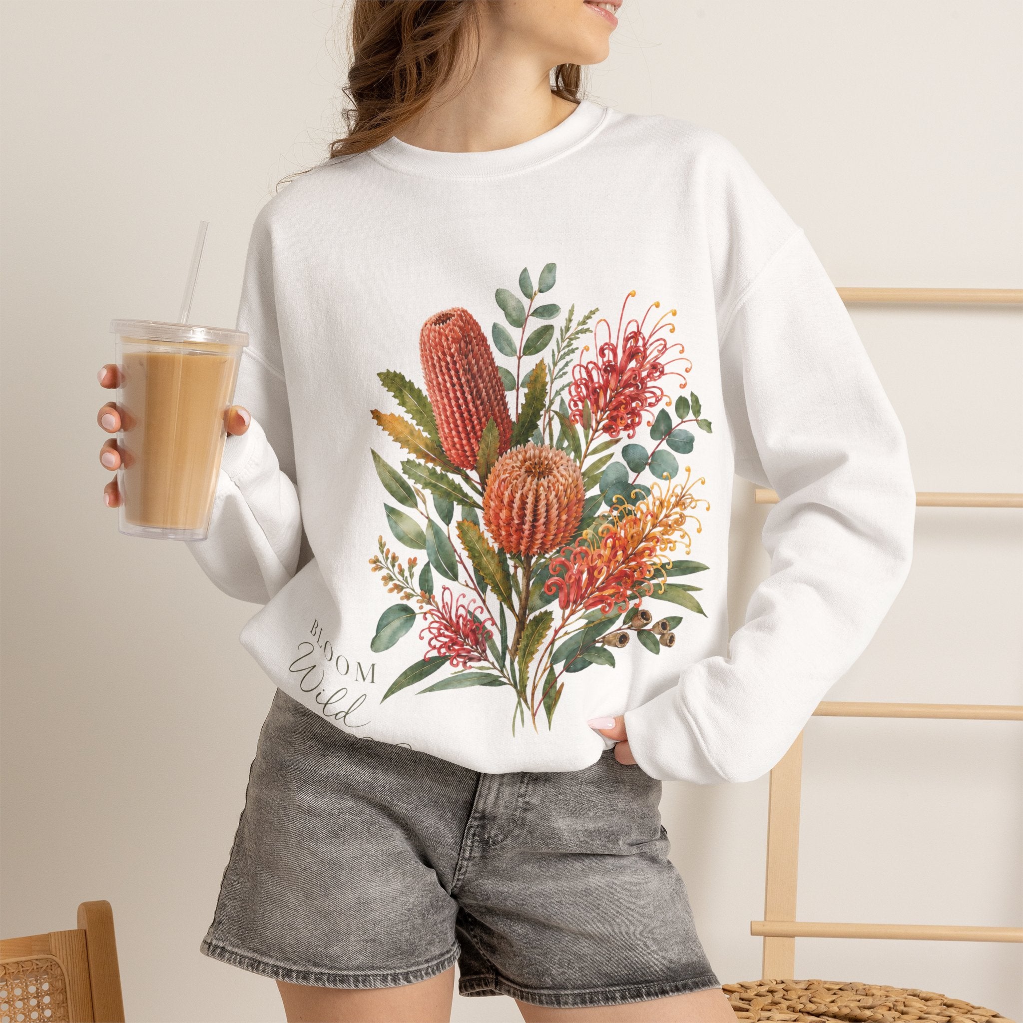 White crewneck sweatshirt with colorful wildflower graphic on the front, long sleeves