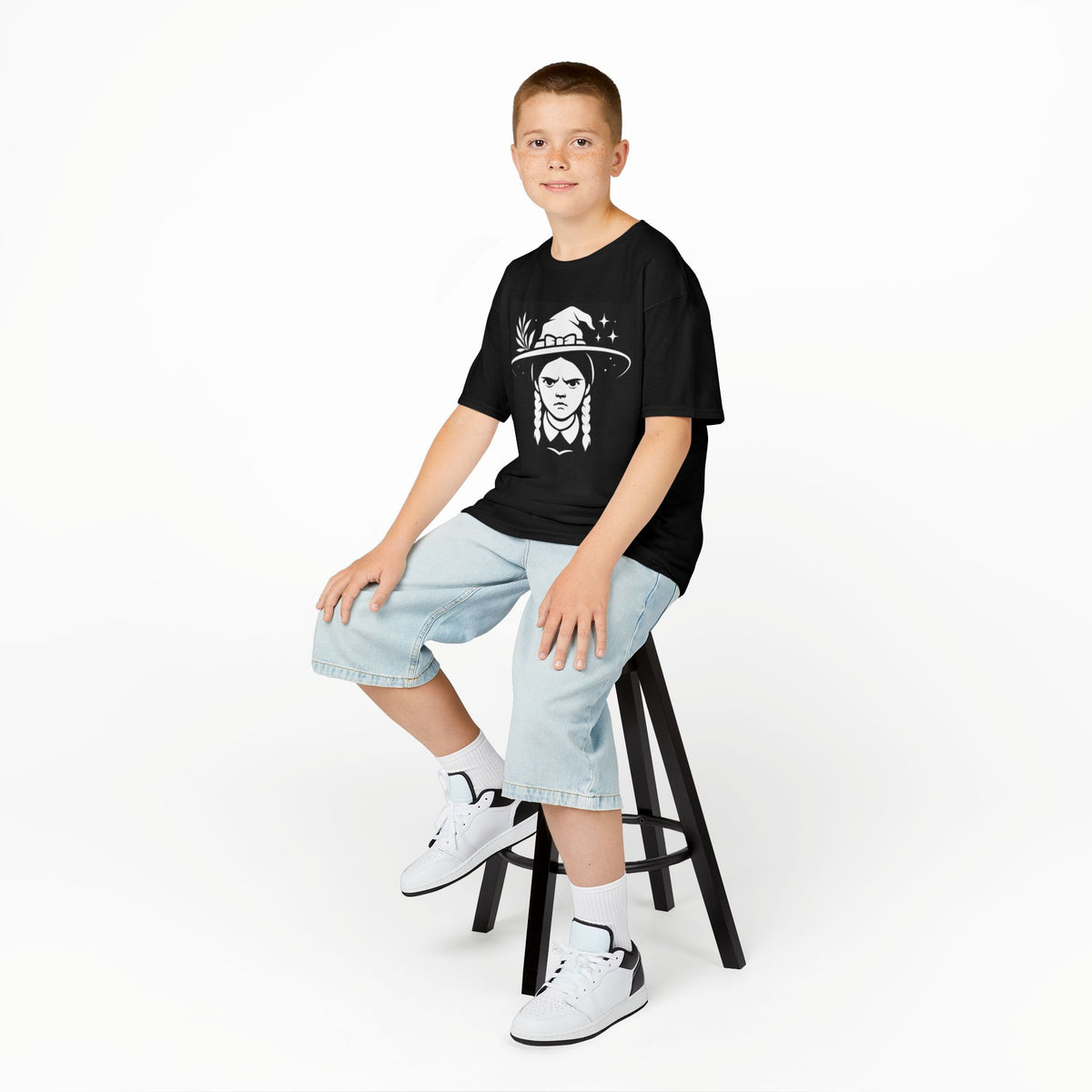 Kids black witch graphic T-shirt, child wearing it with light denim shorts and sneakers