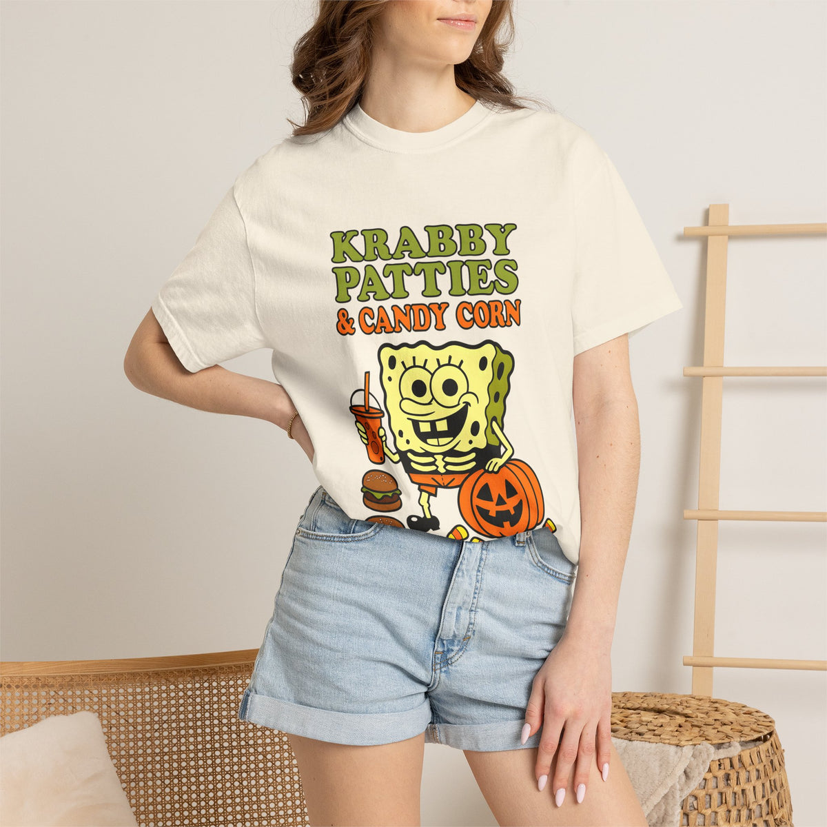 Ivory T-shirt with cartoon sea sponge holding drink and pumpkin print